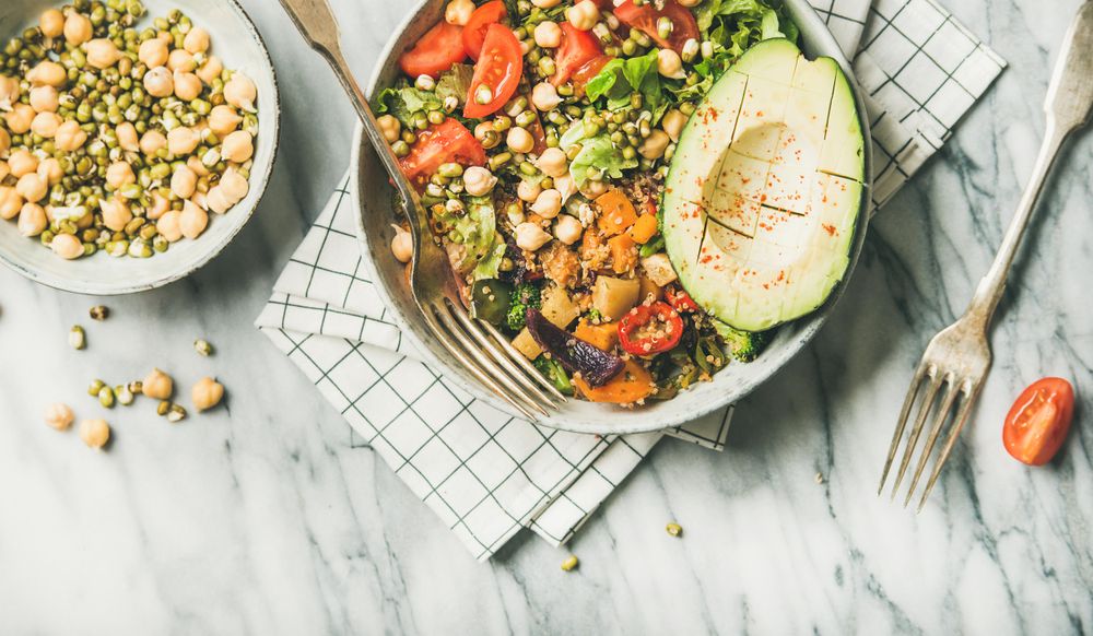 Healthy vegan lunch bowl with avocado, grains, vegetables, horizontal composition, with copy space