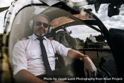 Pilot sitting in the cockpit of a private helicopter 0gXmQ8