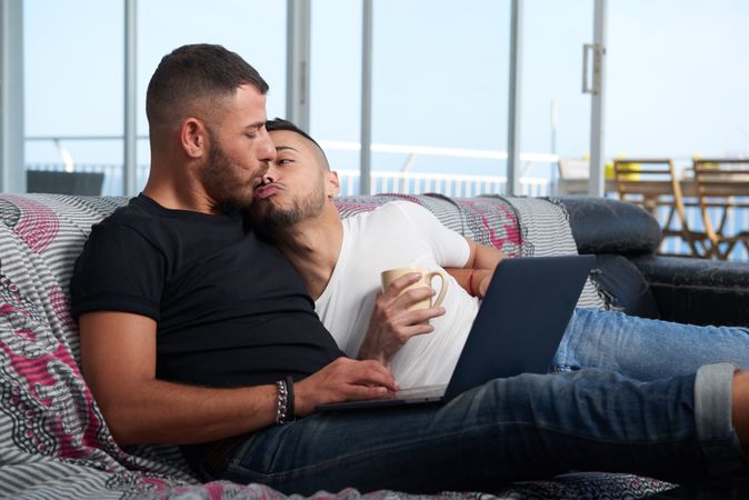 Happy gay couple kissing at home