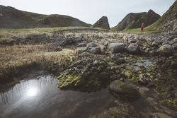 Woman walking along mountain river estuary