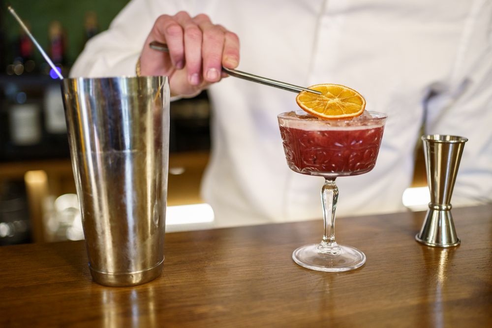 Bartender adding garnish to cocktail