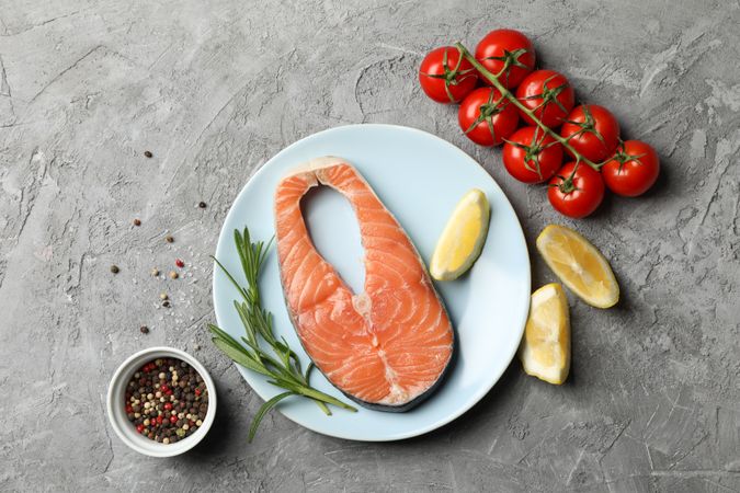Composition with salmon meat and ingredients on gray background, top view