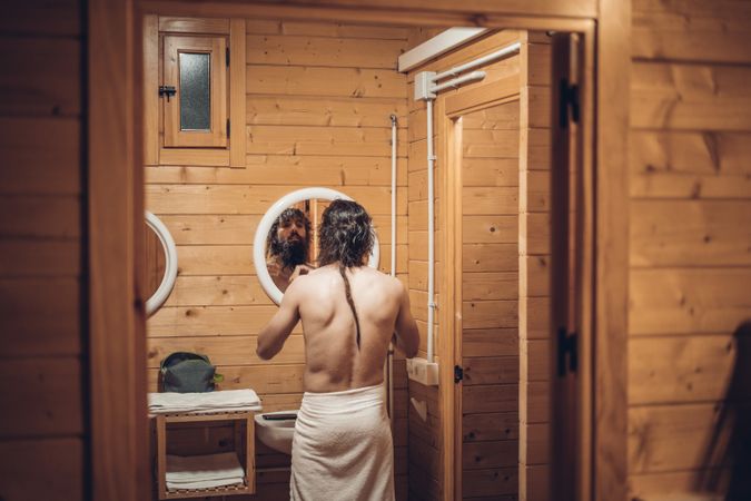 Man getting out of the shower and looking in the mirror