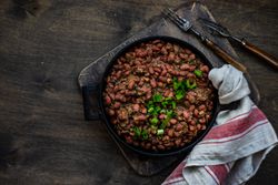 Top view of traditional Georgian lobio dish in cast iron pan on with kitchen towel