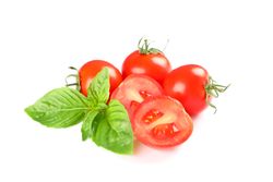 Fresh cherry tomatoes with basil isolated on light background. Ripe vegetables