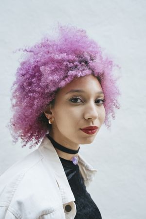 Stylish woman with pink hair looking at camera