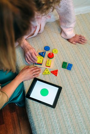 Female doctor showing geometric shapes to older patient