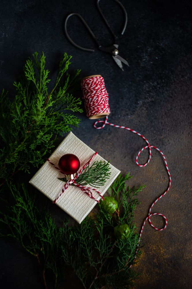 Top view of single Christmas gift with red bauble and fir