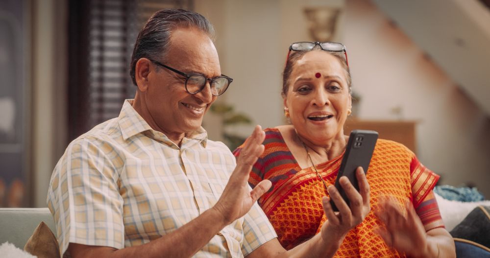Mature Indian Couple Using Smartphone for Video Call at Home