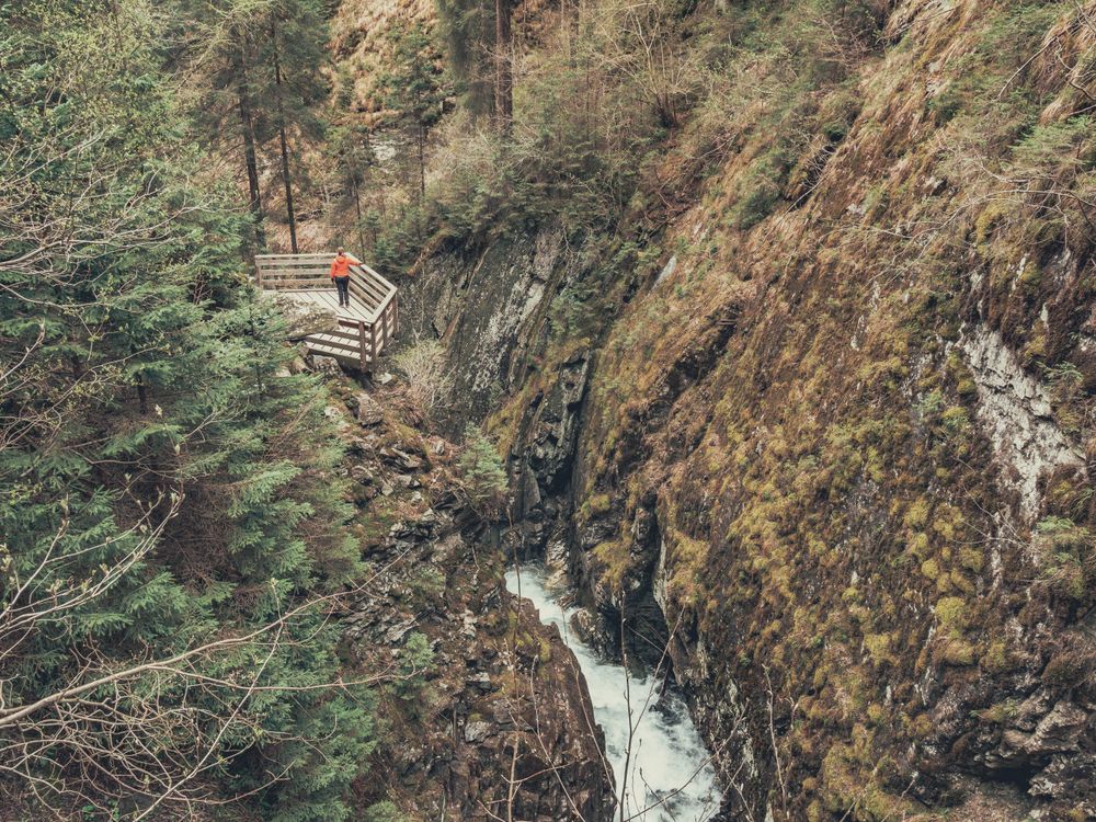 Traveller admiring picturesque view of mountain stream
