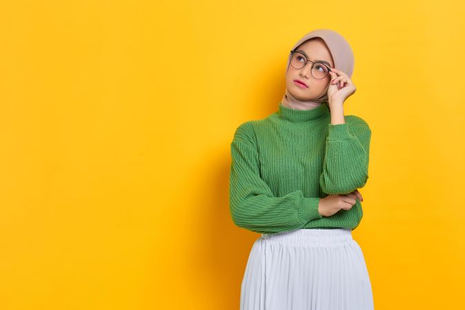 Woman in headscarf adjusting her glasses