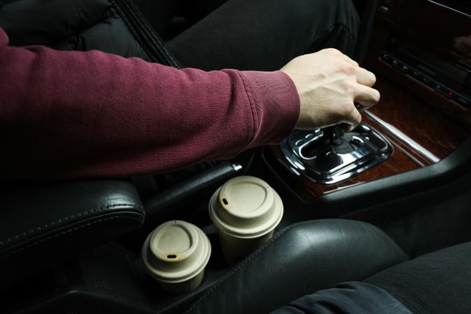 Hot coffee in the interior of the car, near the driver