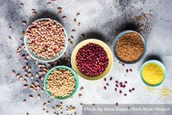 Bowls of dried grains and legumes from pantry on grey counter with copy space 426gQe