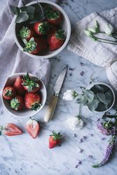 Strawberries and flowers on marble table