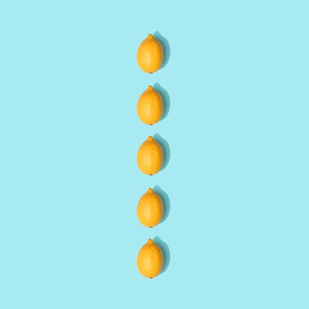 Row of lemons on pastel blue background