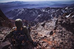 Tourist resting at tranquil mountain valley while hiking