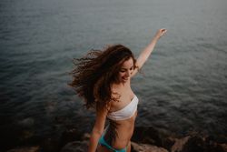 Smiling female dancing near sea