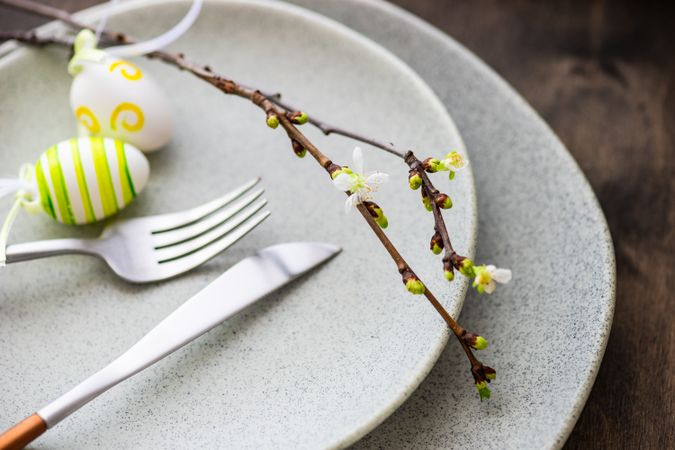 Table setting for Easter dinner with egg ornaments and branch