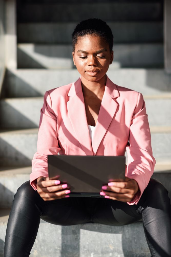 Female in pink suit working on stairs outside