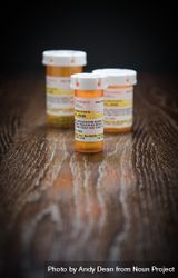 Variety of Non-Proprietary Prescription Medicine Bottles on Reflective Wooden Surface. 4mWx7o