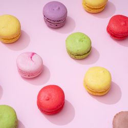 Pastel pink table top with colorful macarons pattern