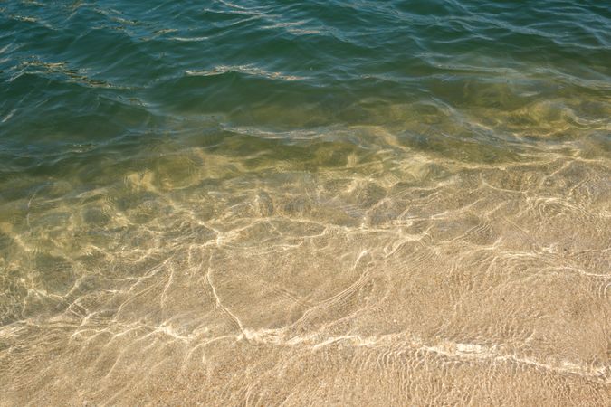 Clear sea water washing sandy shore