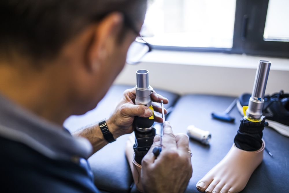 man fixing a prosthesis in a workshop