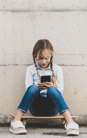 Kid using mobile phone with skate
