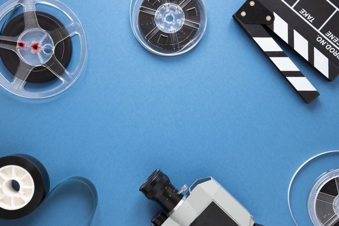 Arrangement of film making accessories on blue background with copy space