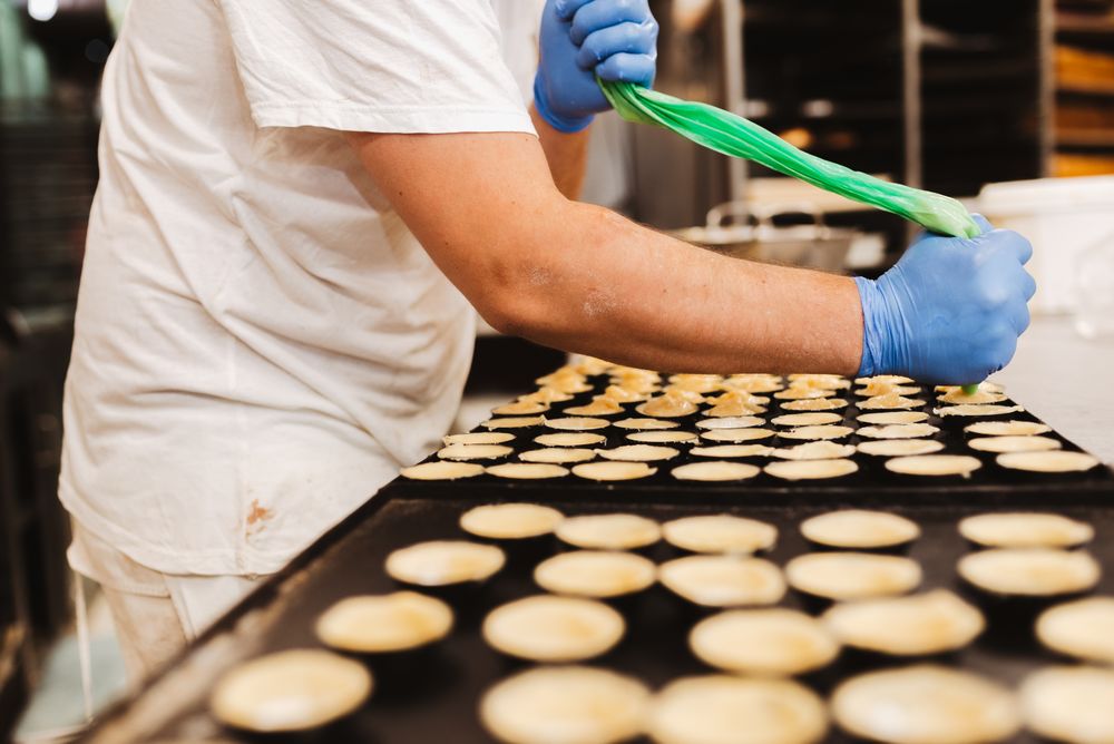Crop baker squeezing dough on tray