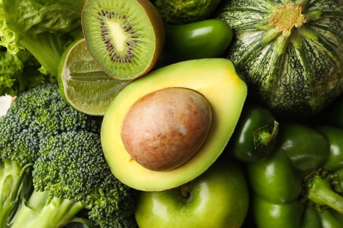 Green vegetables and fruits on whole background, close up