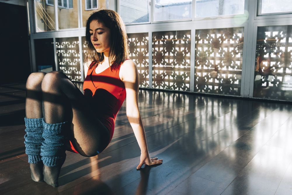 Young woman in bodysuit training in studio