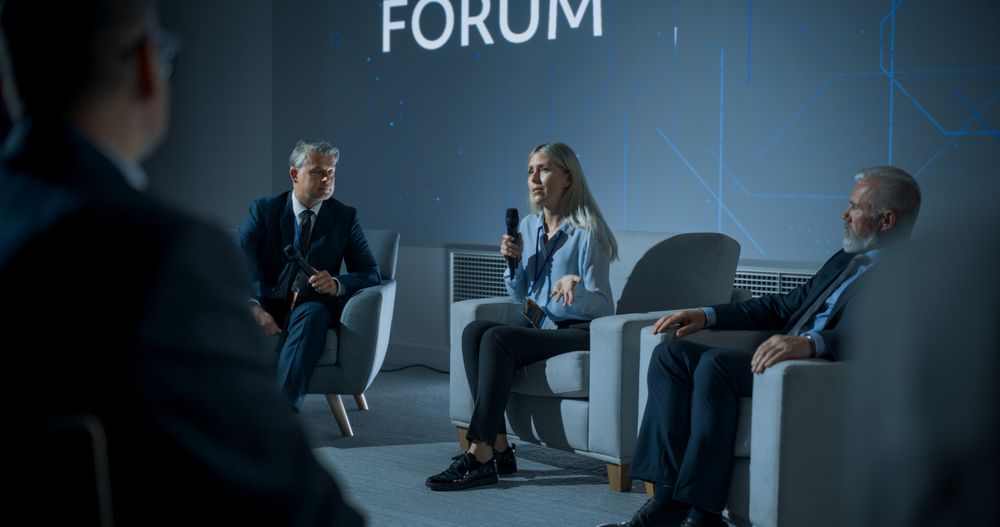 International Technology Conference: Male Host Asking Female CEO a Question In Front Of Audience.