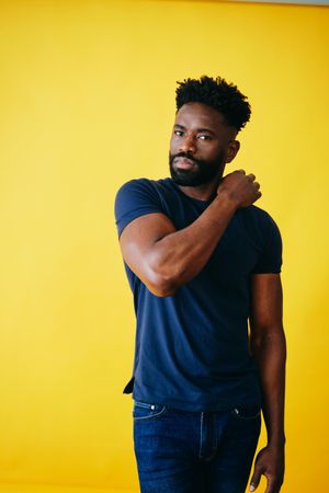 Portrait of Black man with one arm across his shoulder