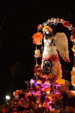 Paper Mache angel sculpture at atlar at Day of the Dead celebration at night