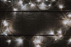 Christmas tree lights decoration on bright wooden background
