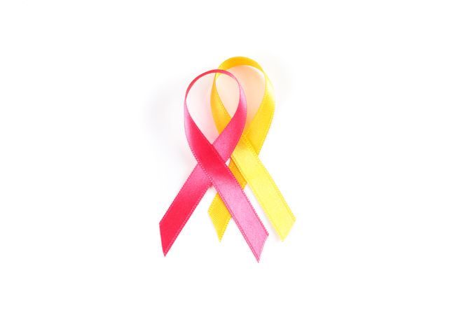 Pink and yellow awareness ribbons isolated on blank background