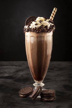 Chocolate milkshake with pieces of chocolate chip cookies.