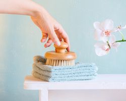 Hand reaching for bathing brush on blue background