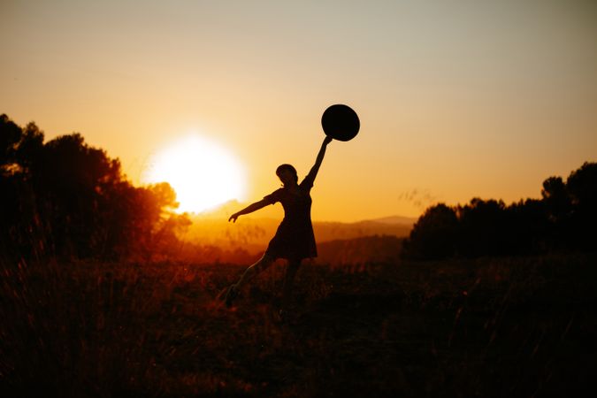 Anonymous woman dancing during sundown
