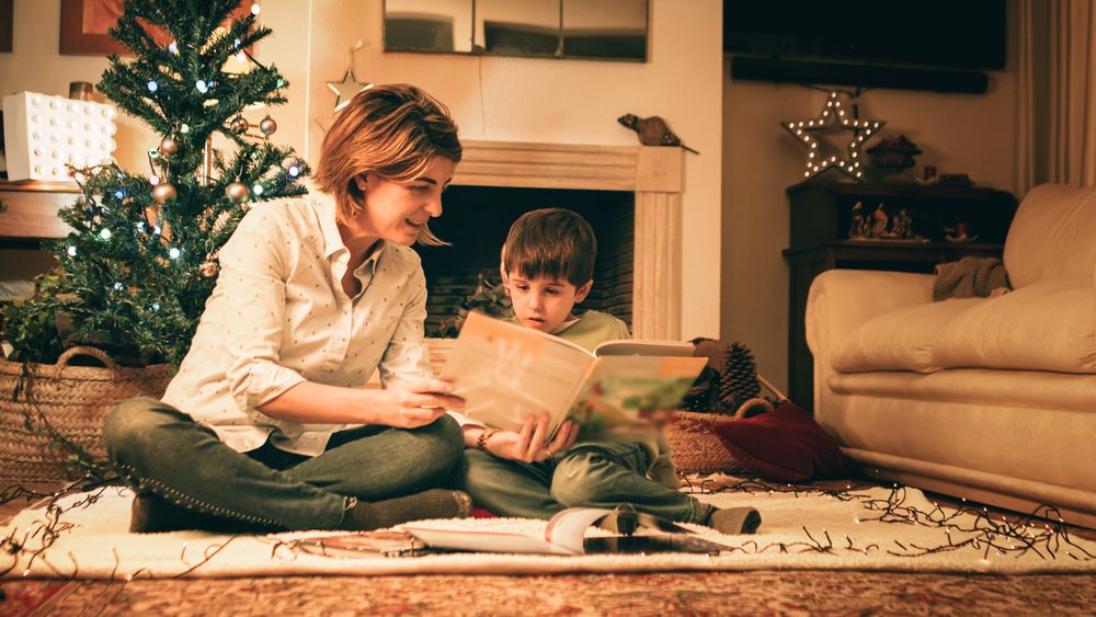 Mother reading book with son on Christmas eve
