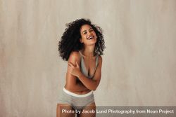 Smiling young Black woman posing in her natural body 0gPl75