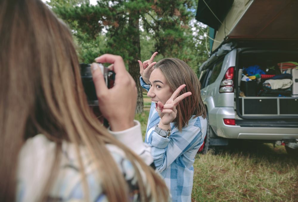 Woman taking photo to friend showing victory sign