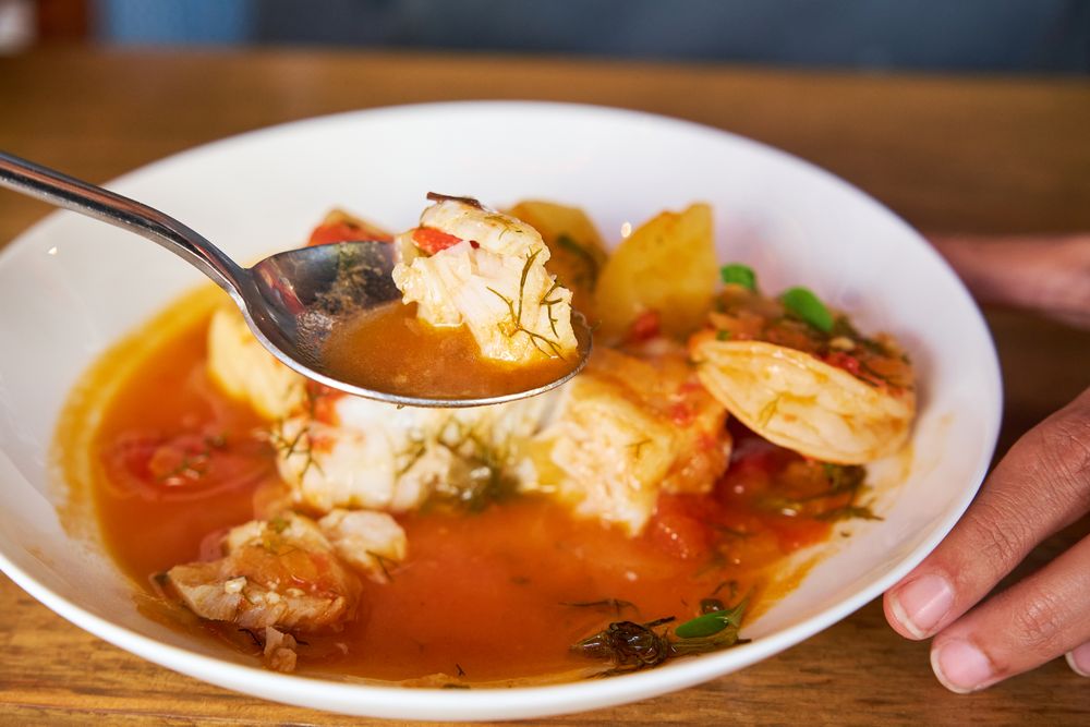 Selective focus on a spoon with fish from a casserole with cod a
