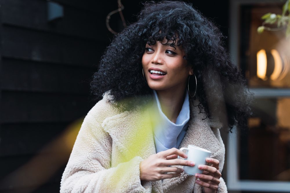Smiling Black woman with cup of coffee