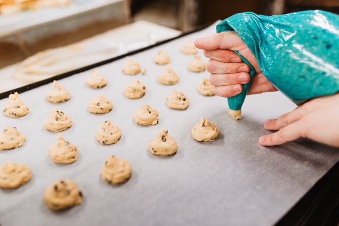 Crop baker squeezing dough on tray
