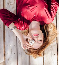 Woman looking through donuts hole on picnic