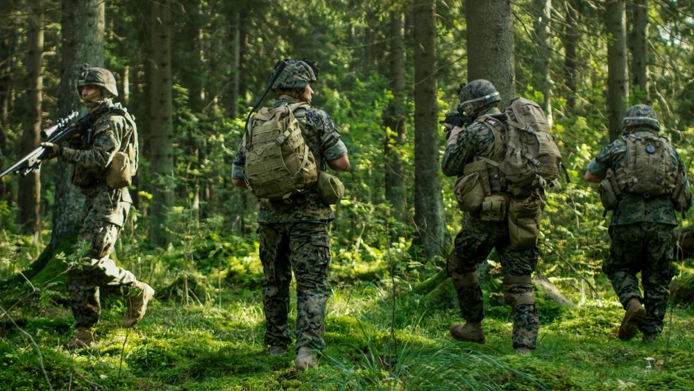 Squad of Five Fully Equipped Soldiers in Camouflage on a Reconnaissance Military Mission, Rifles in Firing Position