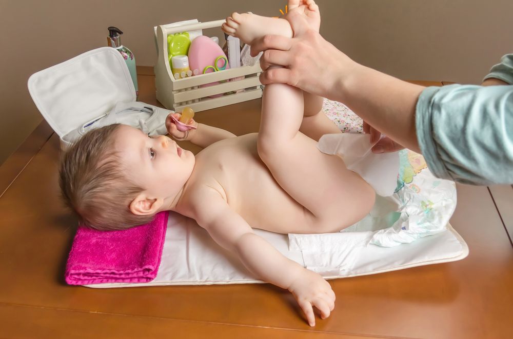 Parent cleaning baby while changing diaper