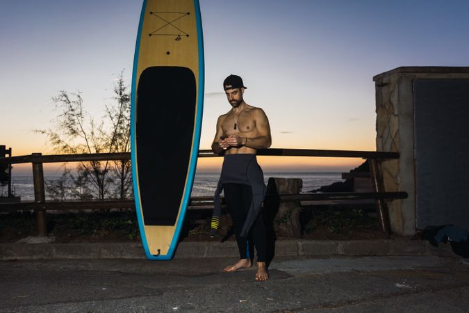 Man practicing paddle surfing with neoprene in a sunrise